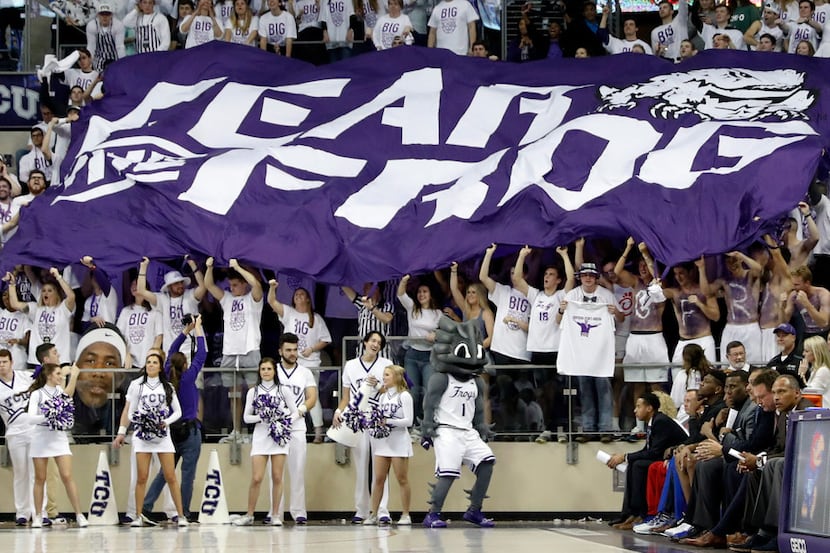 TCU fans hold up a giant flag that reads, "Fear The Frog", behind the Kansas bench, bottom...