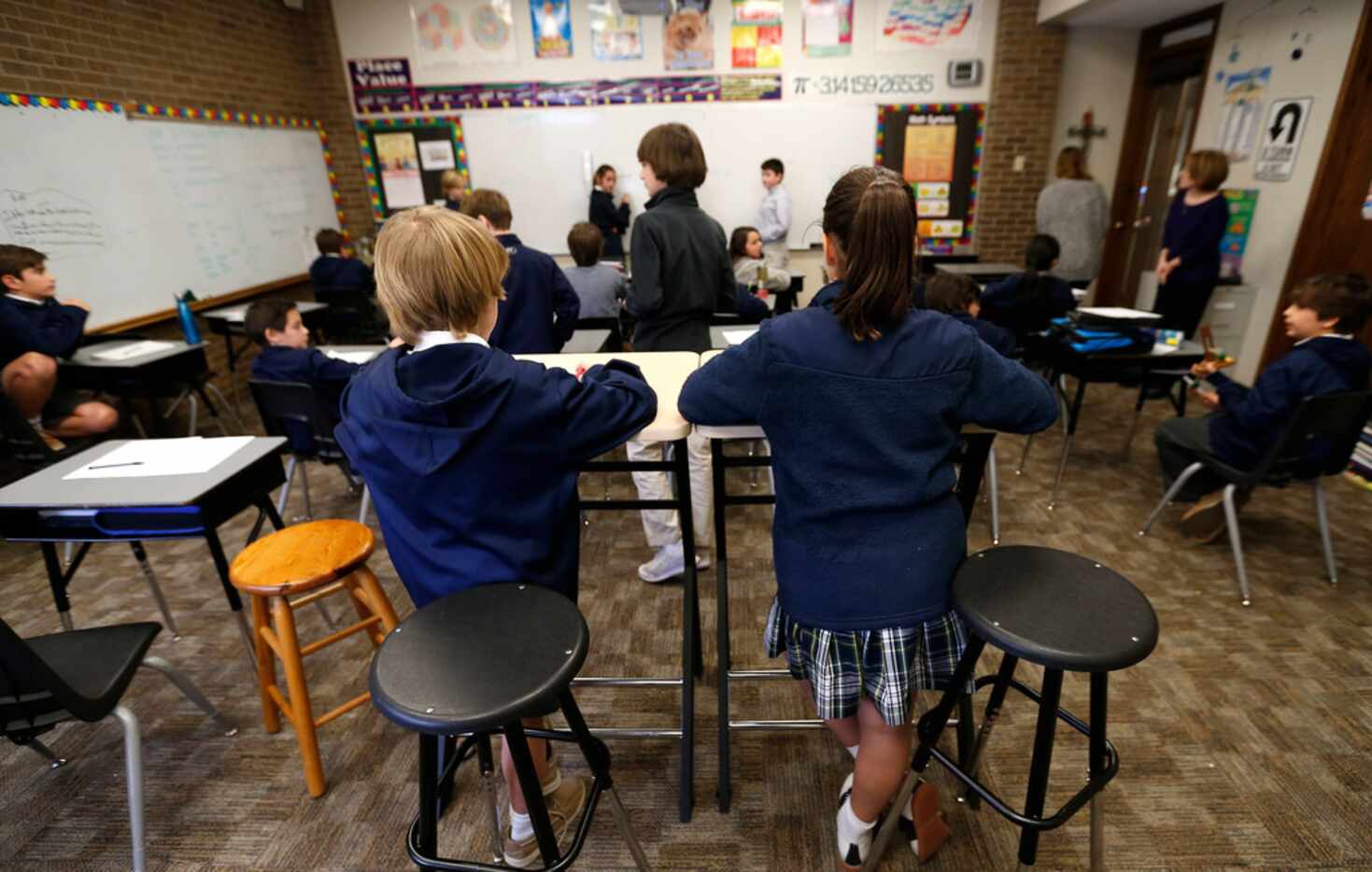 Fifth-graders Rett Detwiler, 11, left, and Parmida Zandinejad, 10, use standing desks during...
