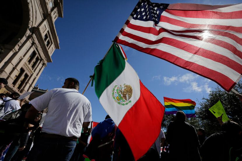 A man hold the U.S and Mexico flags during a march and rally during an immigration protest,...
