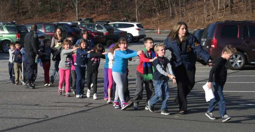 In this file photo, Connecticut State Police lead a line of children from the Sandy Hook...