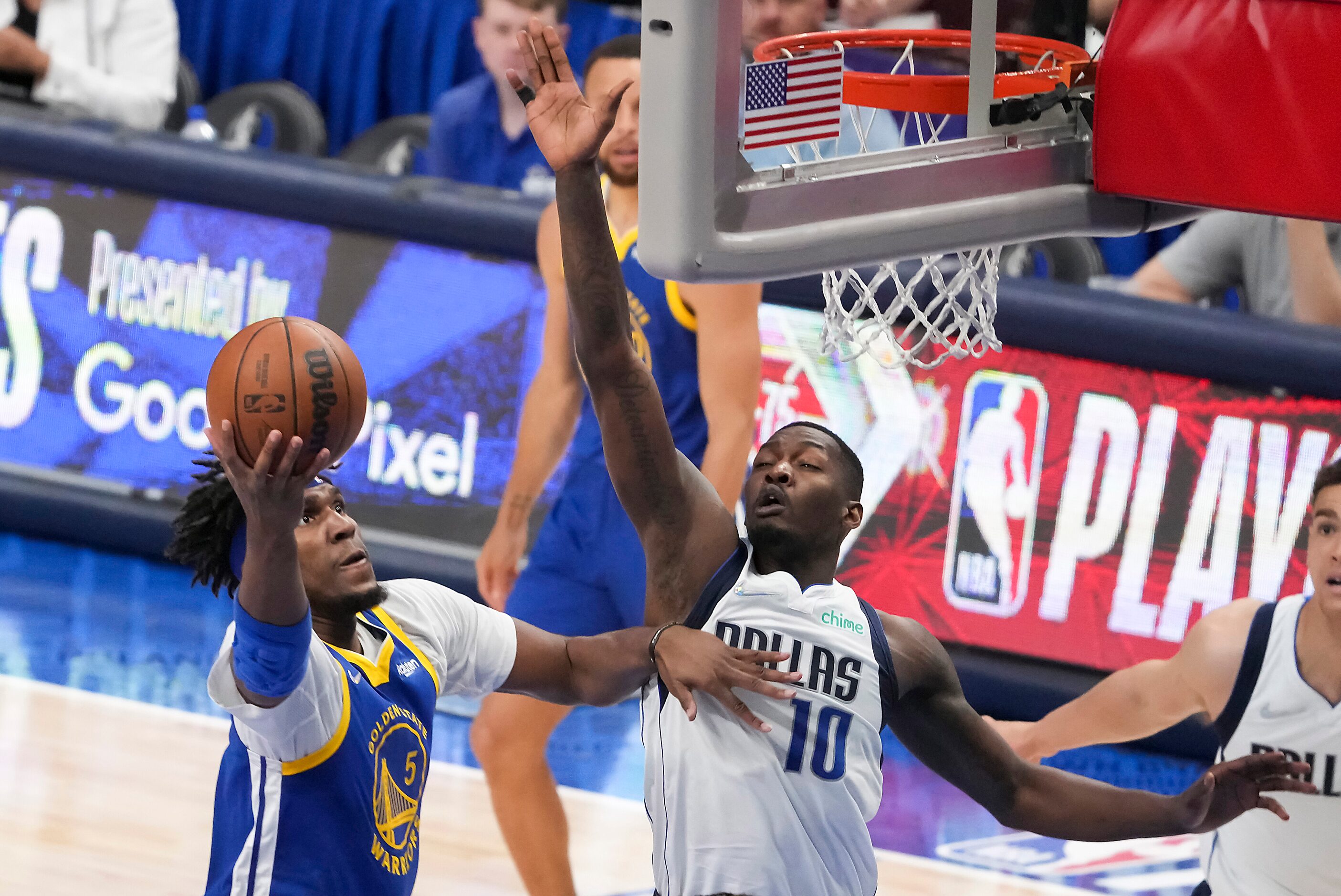 Golden State Warriors center Kevon Looney (5) scores past Dallas Mavericks forward Dorian...