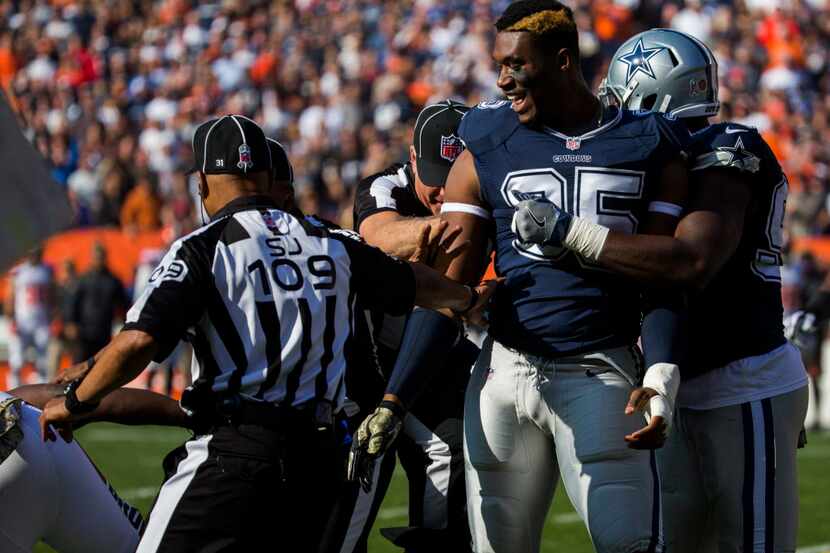 Dallas Cowboys defensive tackle David Irving (95) is held back after being punched and...