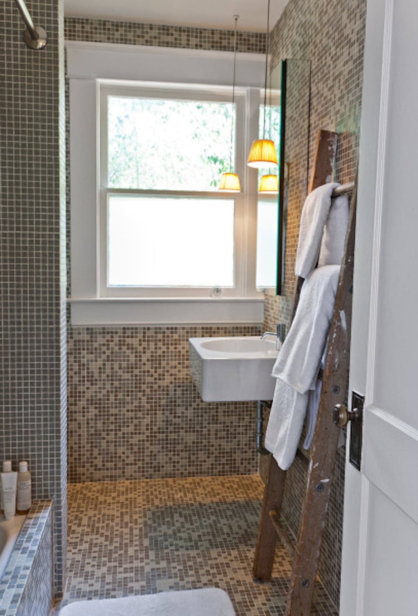 The bathroom was redone by Dallas designer Murray Woodall with custom glass tiles, a...