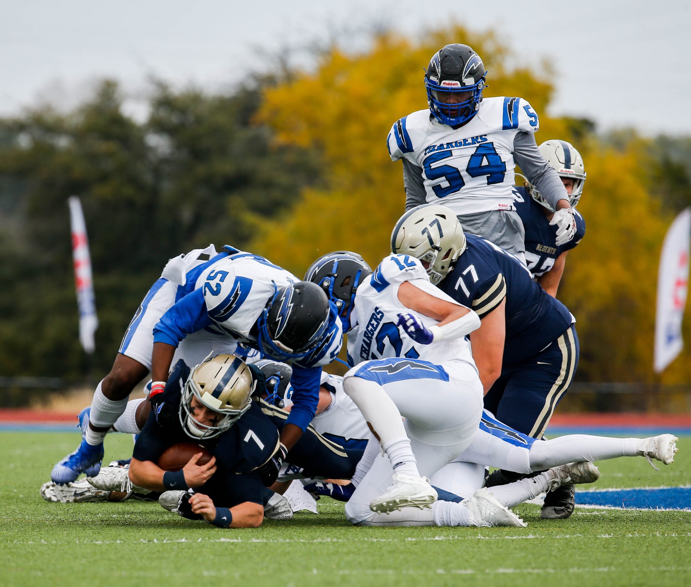 Dallas Christian's defense pile over Austin Regents' quarterback Andrew Dickey (7) during...