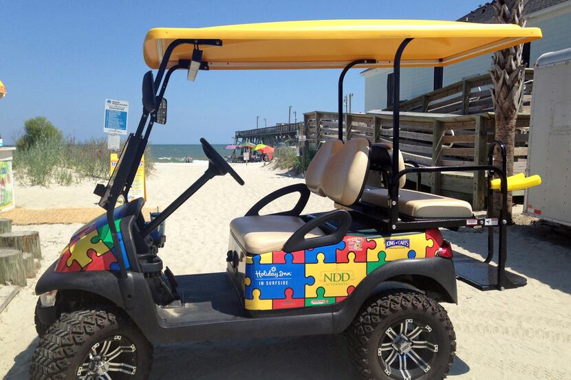 This July 21, 2017 photo shows a Champion Autism Network golf cart decorated with puzzle...