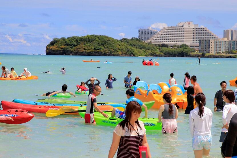 Tourists enjoy the activities along Tumon beach on the island of Guam on August 11, 2017....