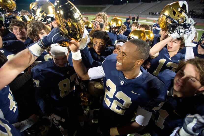 Jesuit senior running back E.J. Smith (22) raises the trophy after his team's 27-25 victory...