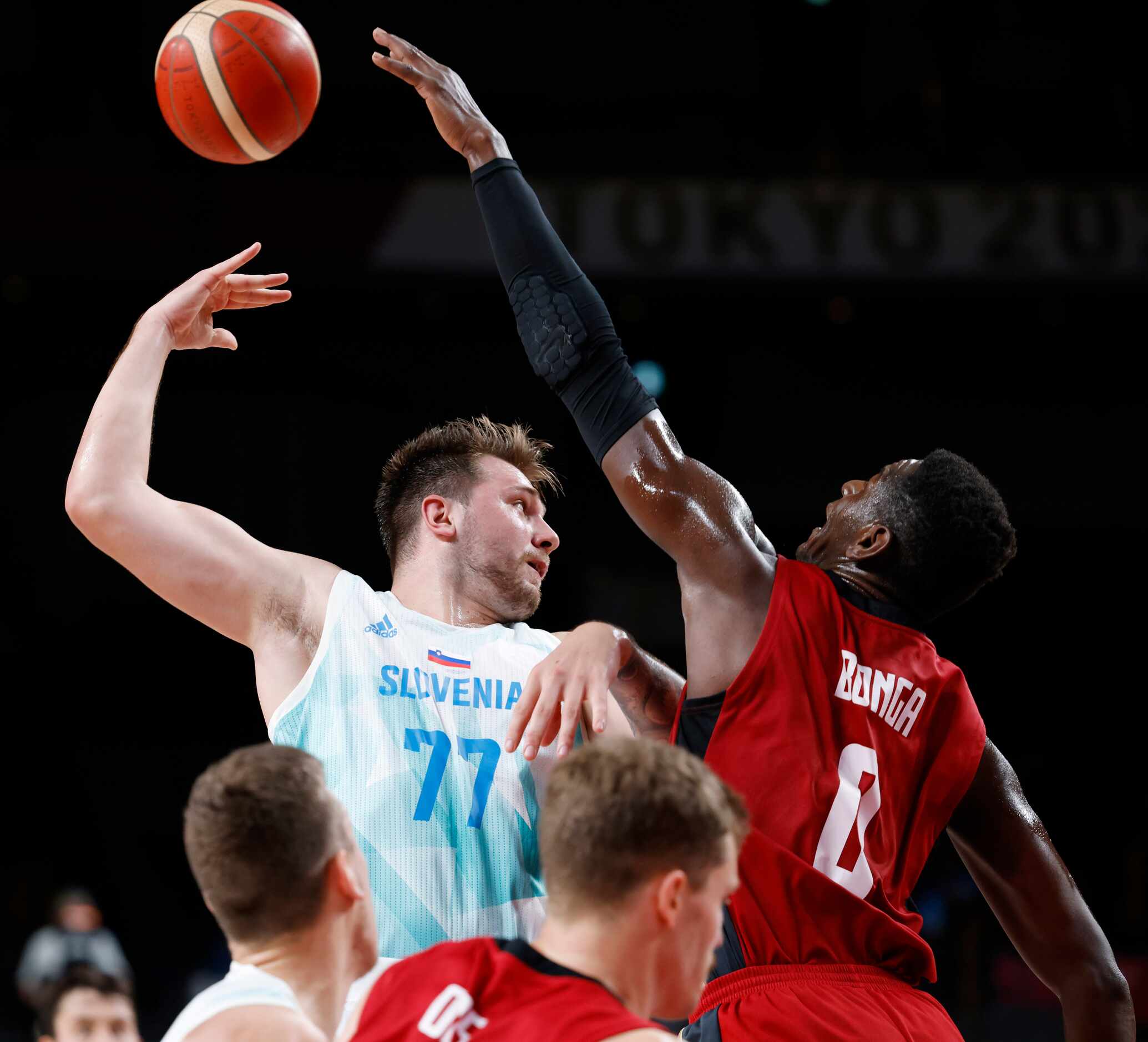Slovenia’s Luka Doncic (77) passes the ball behind his back as he is defended by Germany’s...