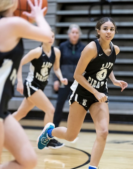 Crandall girls basketball head coach Laura Holmes, background, watches as her daughter, a...