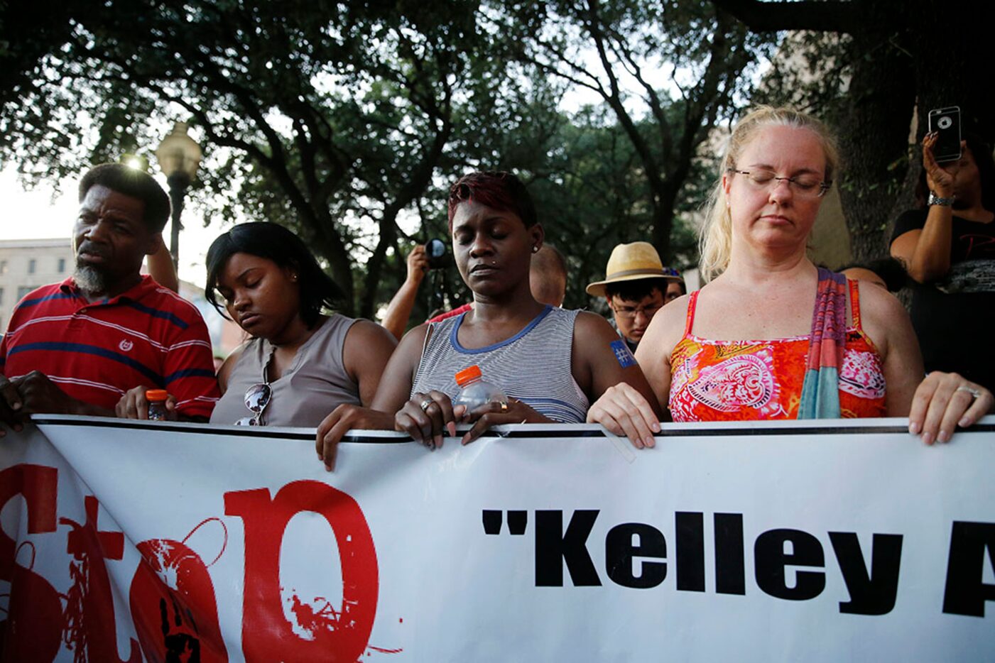 Protesters close their eyes as Dominique Alexander, president of Next Generation Action...