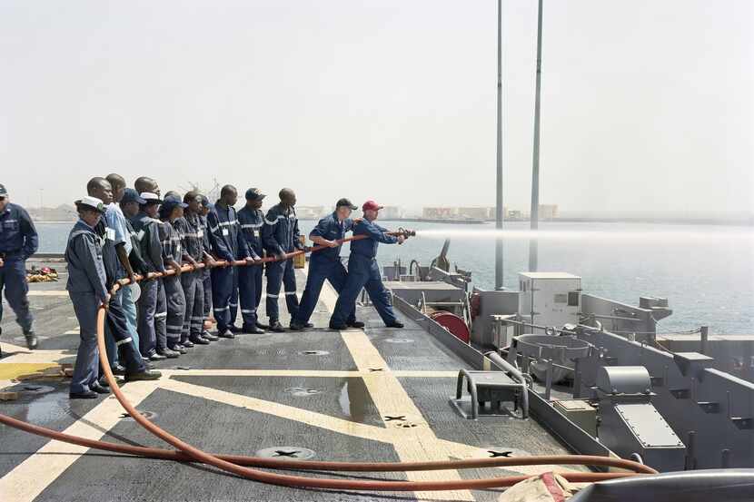 Sailors train with a fire hose in An-My Lê's 2009 photograph "Damage Control Training, USS...