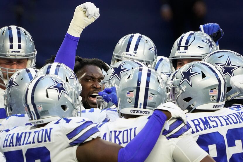 Dallas Cowboys defensive end DeMarcus Lawrence (facing) fires up his teammates before an NFL...