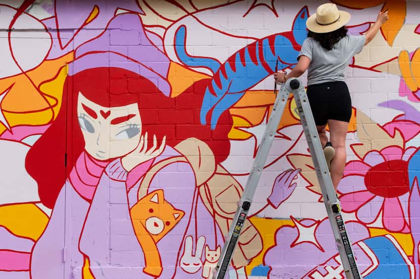 In this Oct. 22, 2020, file photo, Stephanie Sanz works on a mural with artist Brent Ozaeta...