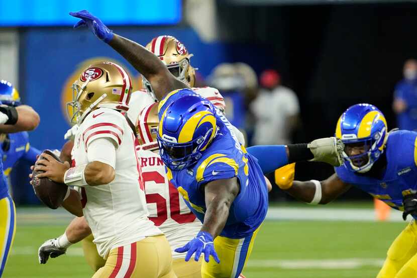 Los Angeles Rams' A'Shawn Robinson, middle, applies pressure to San Francisco 49ers' Jimmy...