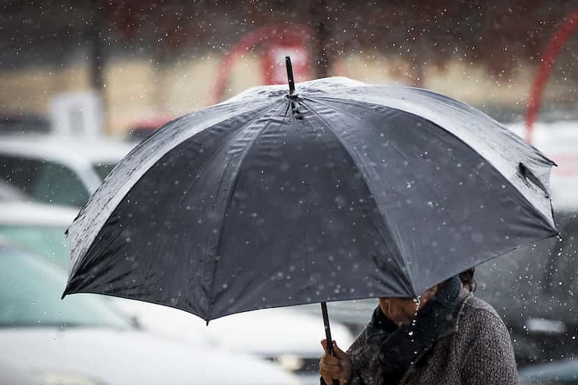 Shoppers bundle against a cold rain in the Wheatland Towne Crossing parking lot on Dec. 22,...