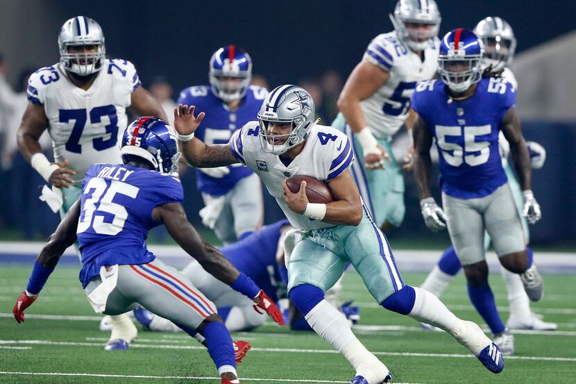 Dallas Cowboys quarterback Dak Prescott (4) cuts back across the field as New York Giants...