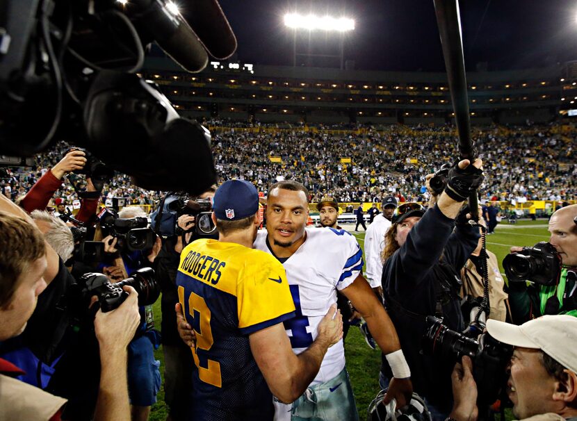 Dallas Cowboys quarterback Dak Prescott (4) hugs Green Bay Packers quarterback Aaron Rodgers...