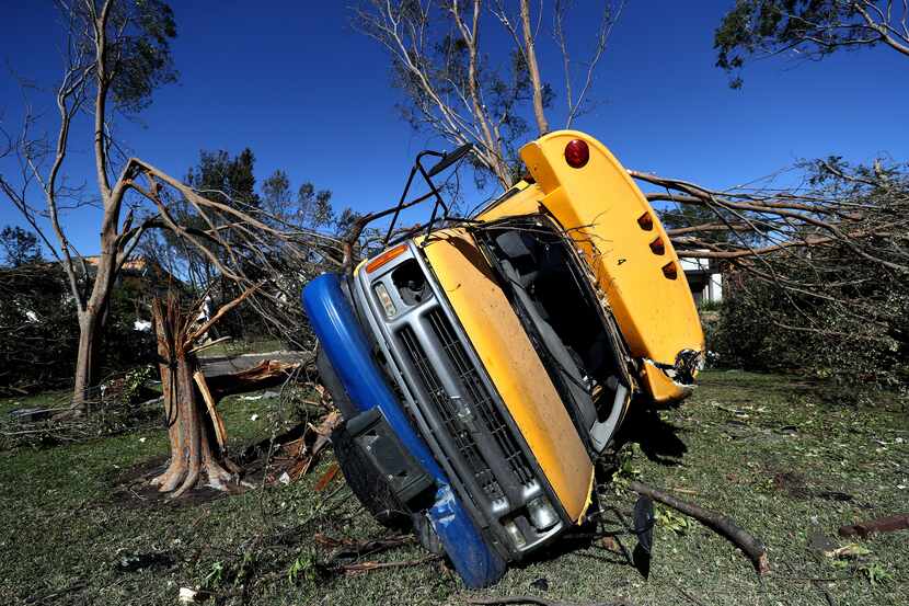 DALLAS, TEXAS - OCTOBER 21: A St Mark's School of Texas school bus lies on top of a tree on...