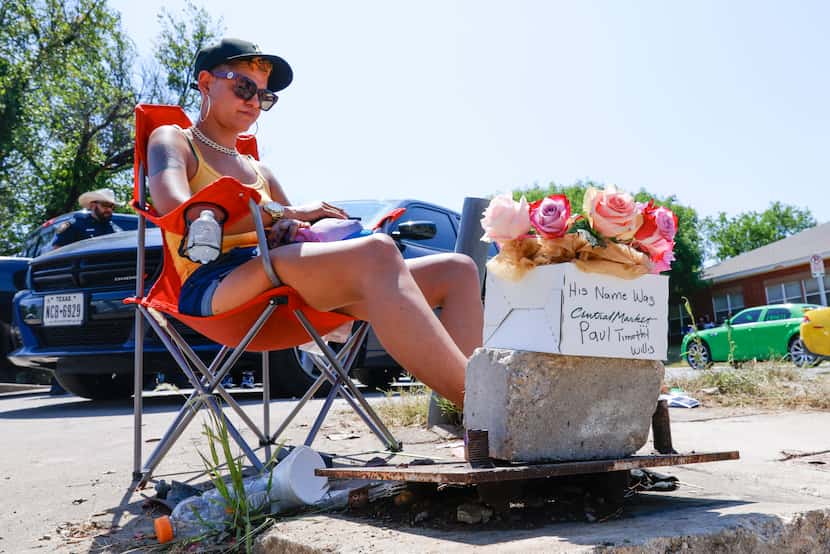 Ka’Desha Weatherly, mother of shooting victim 18-year-old Paul Willis,  sits by a flower...
