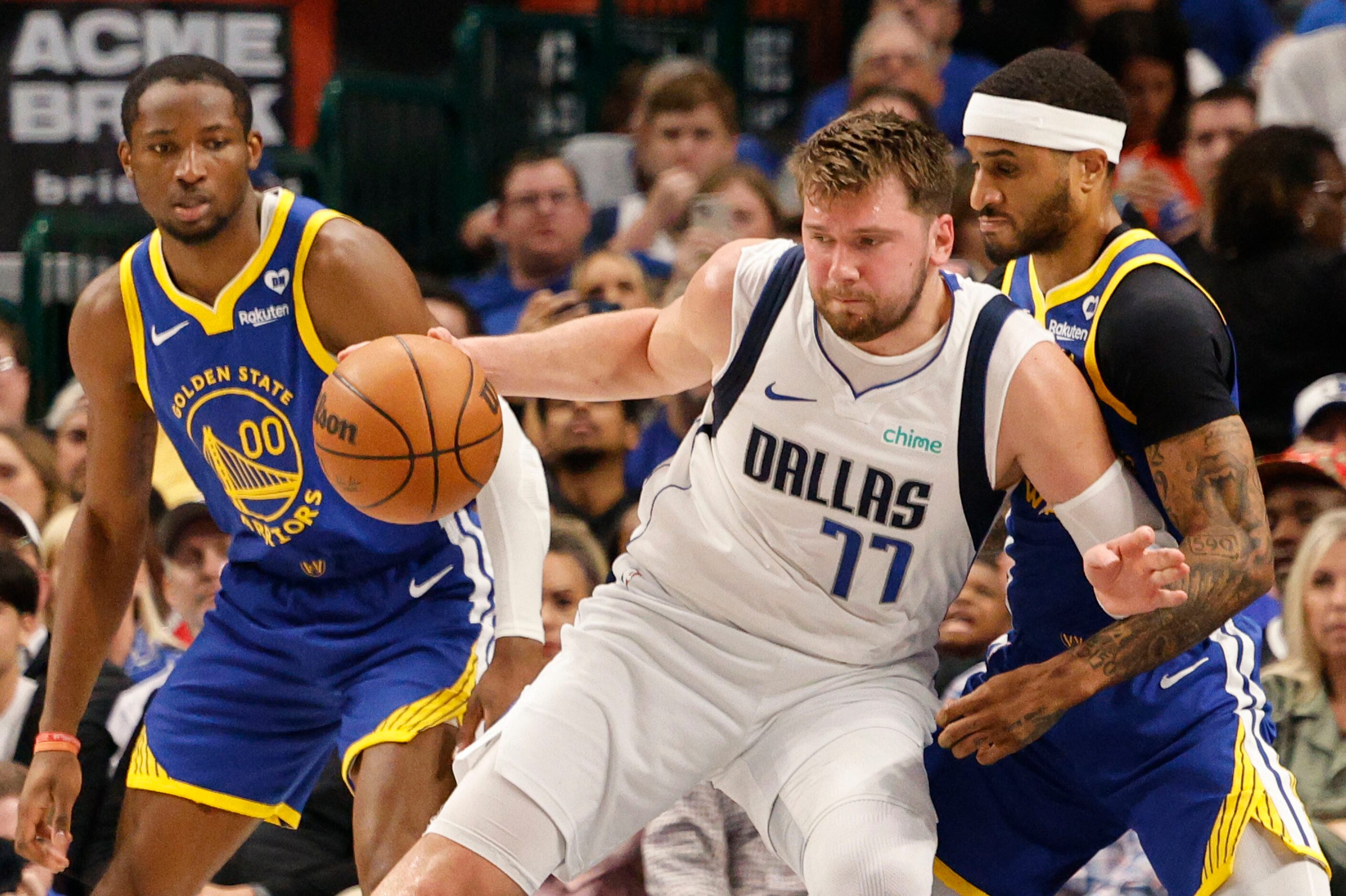 Dallas Mavericks guard Luka Doncic (77) keeps the ball away from Golden State Warriors guard...