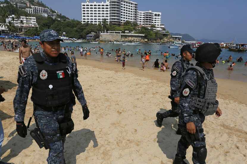 Policías federales vigilan la playa en Acapulco, Guerrero. (AP/ENRIC MARTÍ)
