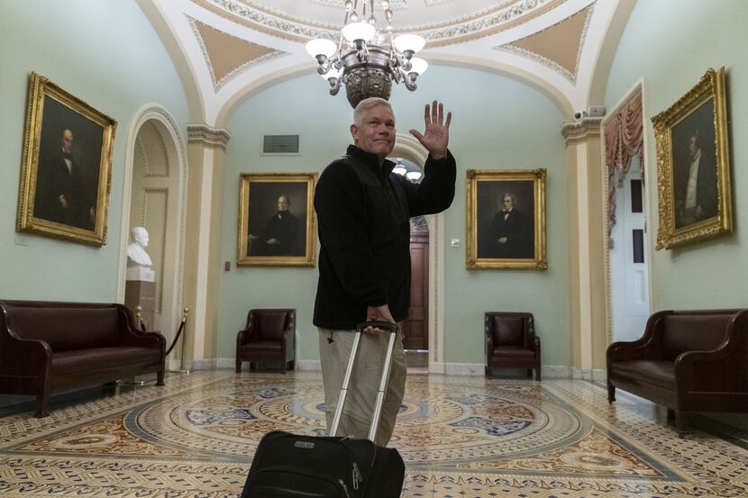 Rep. Pete Sessions waves to reporters as he departs the U.S. Capitol on Dec. 22. 