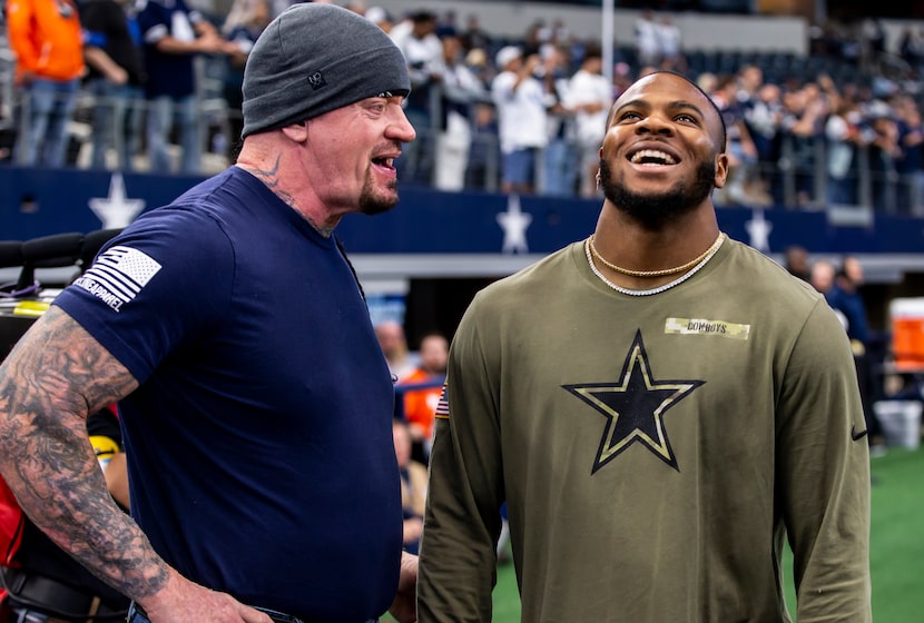 WWE wrestler The Undertaker, left, chats with Dallas Cowboys outside linebacker Micah...