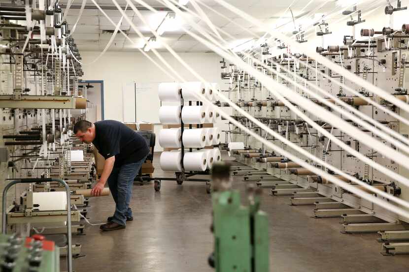 Aaron Reyna, material processing lead, operates the machine that cuts and spools fabric that...