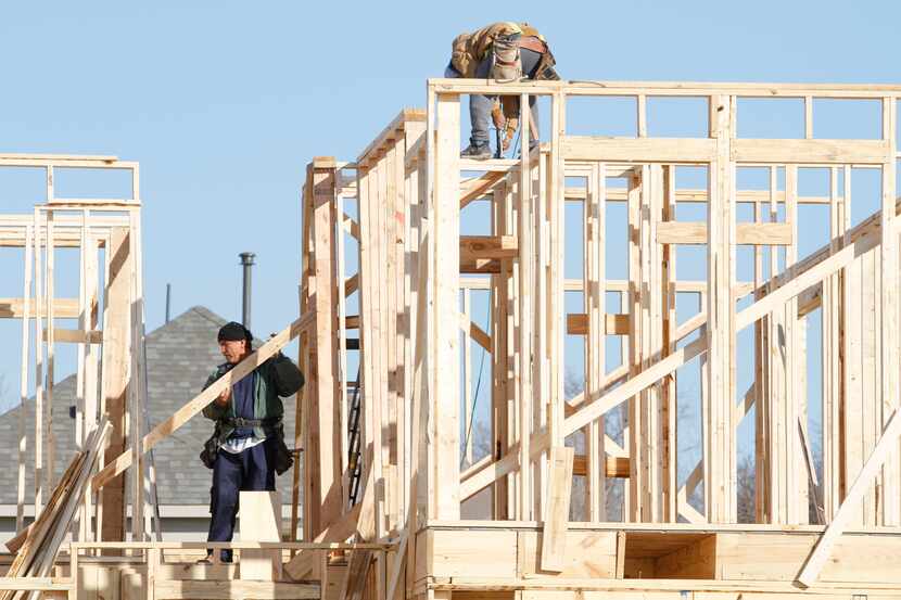 Workers frame a house under construction on Shasta Daisy Road in The Grove neighborhood in...
