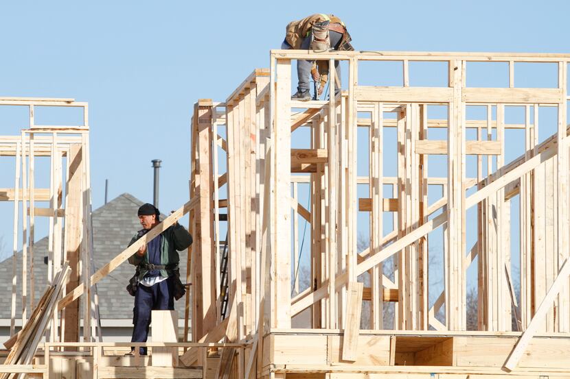 Workers frame a house under construction on Shasta Daisy Road in The Grove neighborhood in...