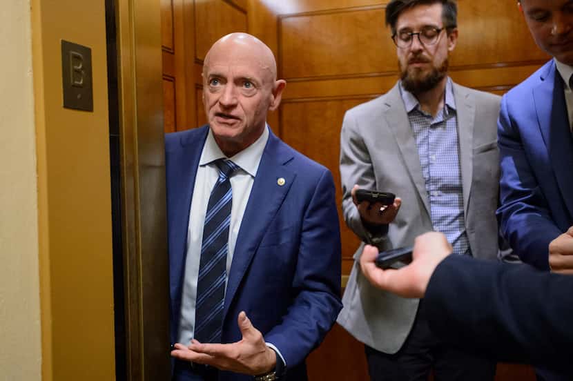 Sen. Mark Kelly, D-Ariz., stops to talk with reporters as he boards an elevator in the...