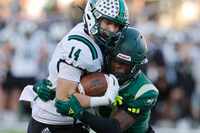 Southlake Carroll's Clayton Wayland (14) is tackled by DeSoto's Sael Reyes (17) during the...