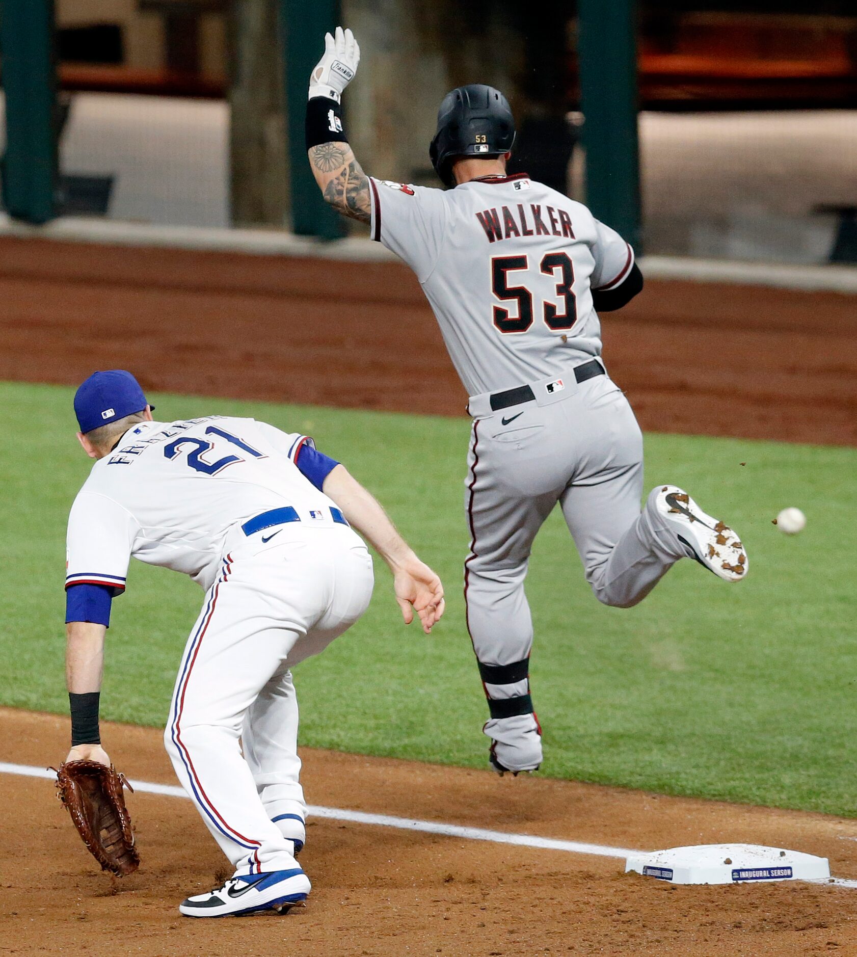 The ball gets away from Texas Rangers first baseman Todd Frazier (21) on a throw from third...