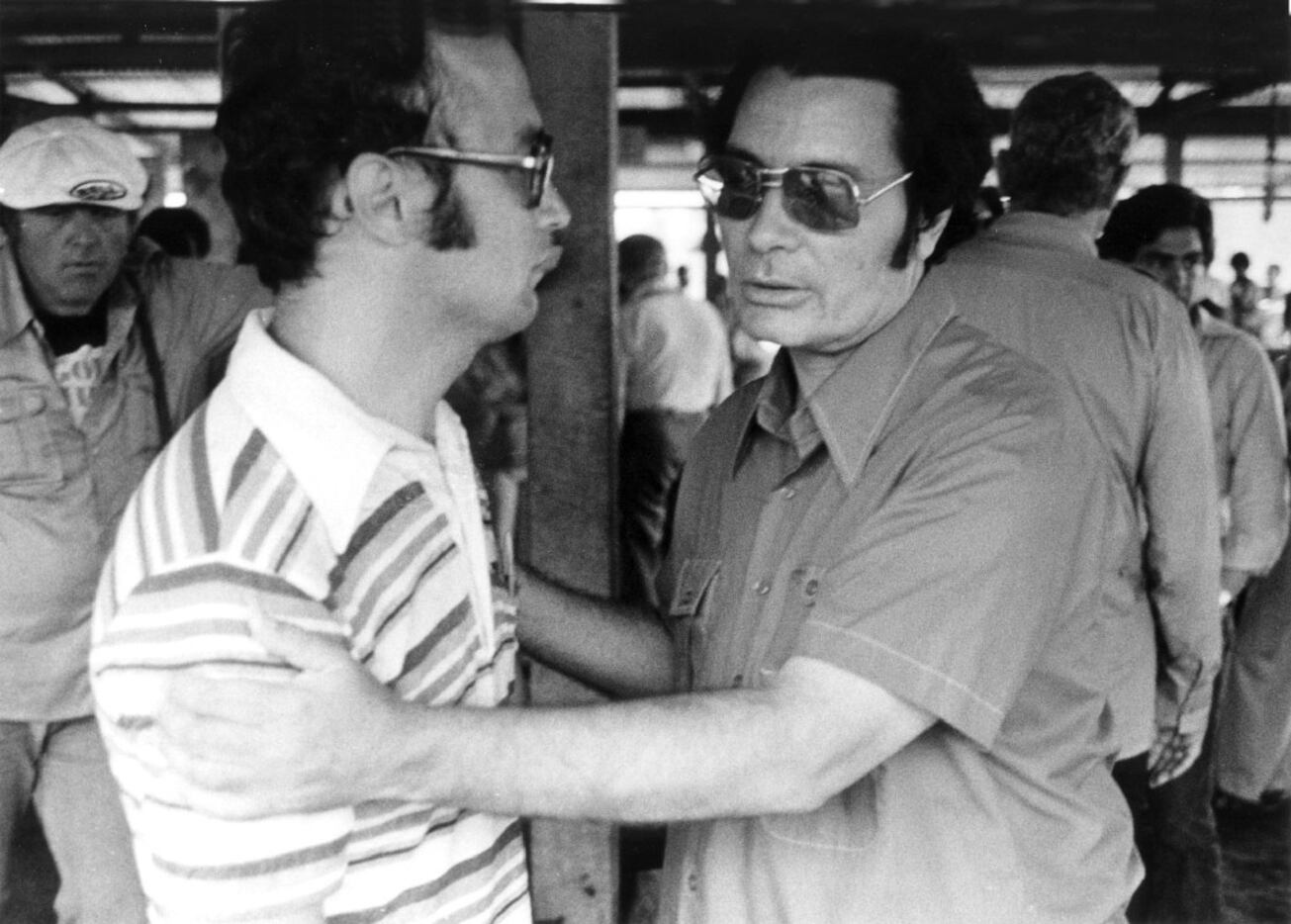 The Rev. Jim Jones, founder of Peoples Temple, clasps an unidentified man at Jonestown on...
