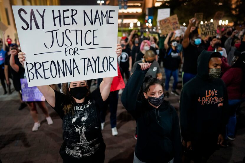 Demonstrators march on Ervay Street near Dallas City Hall after a Kentucky grand jury...