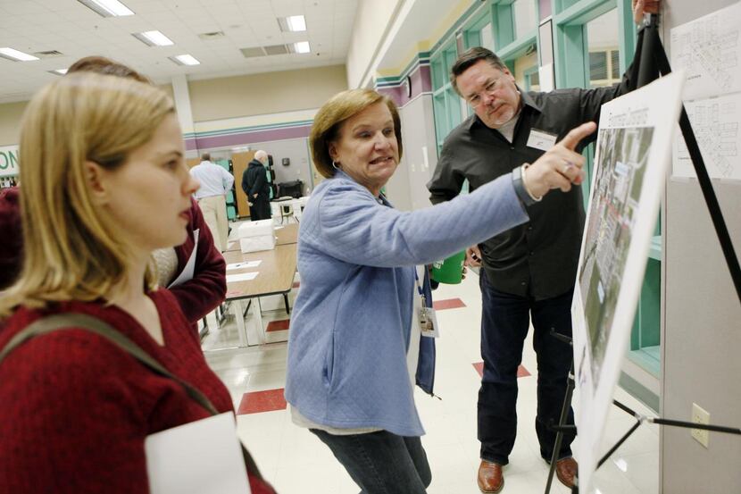 
Anne Ewert (left) listens to Suzanne Teel speaks about a map showing State Highway 276,...