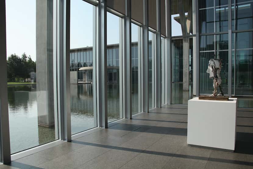 A sculpture with the foreground of water through windows at the Modern Art Museum of Fort Worth