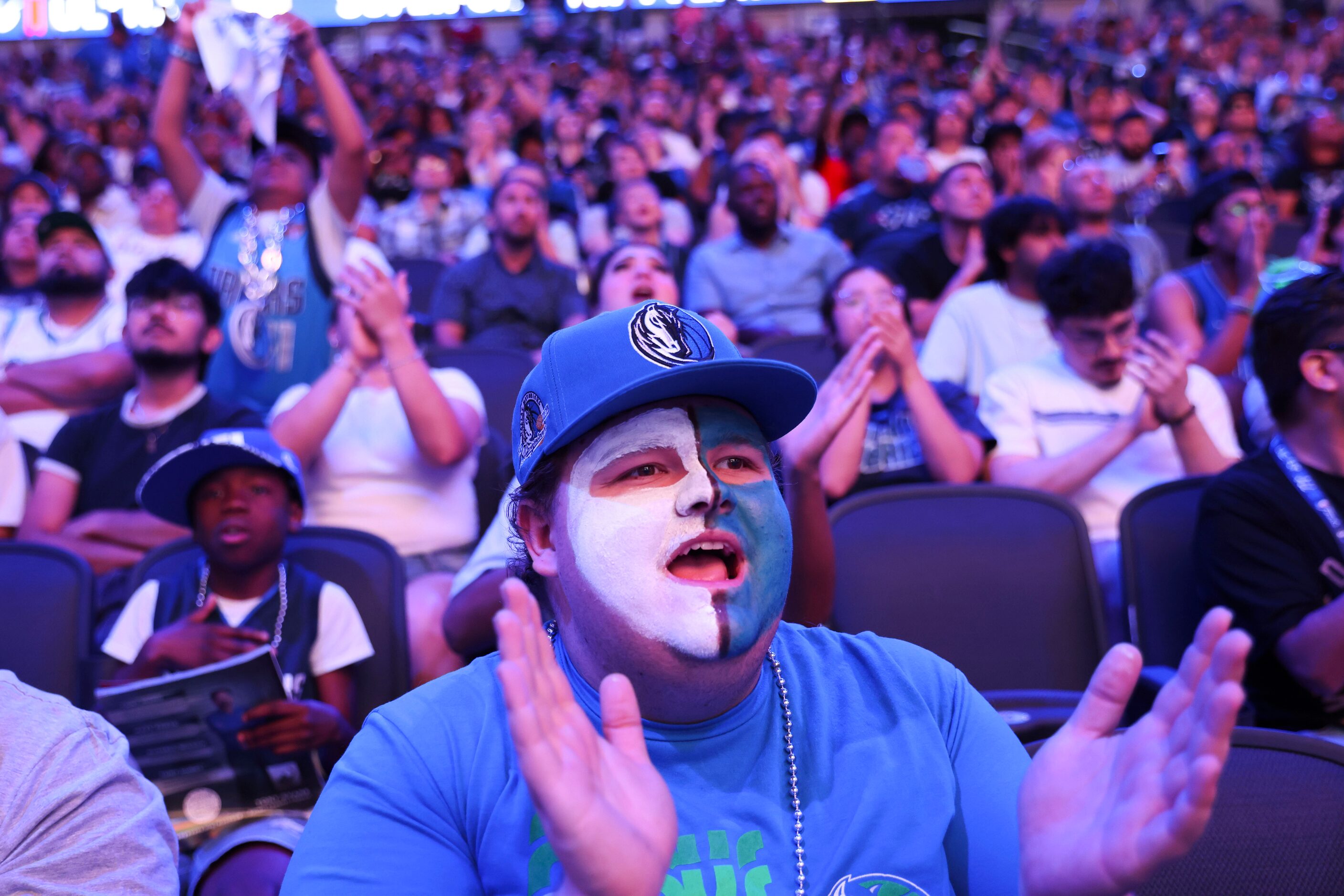 James Barrett of Irving (center), cheers following a Dallas Mavericks point during a watch...