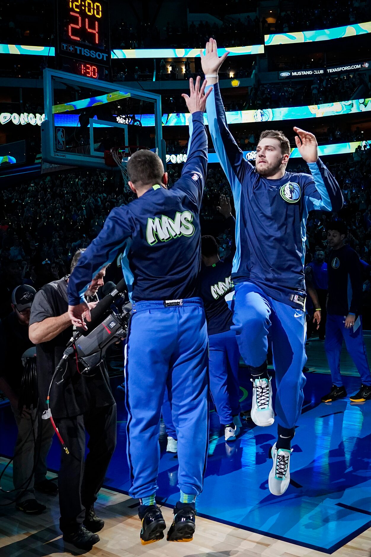 Dallas Mavericks guard Luka Doncic high fives guard J.J. Barea before an NBA basketball game...