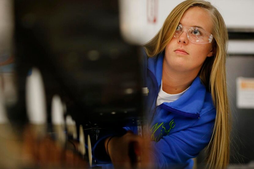 
Makenzie Bass, 17, a McKinney Boyd High School student, works on the center section...