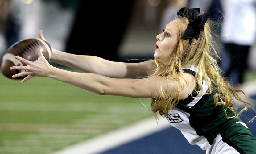 Prosper varsity cheerleader Lauren Gilmore, 18, reaches to make a catch while tossing the...