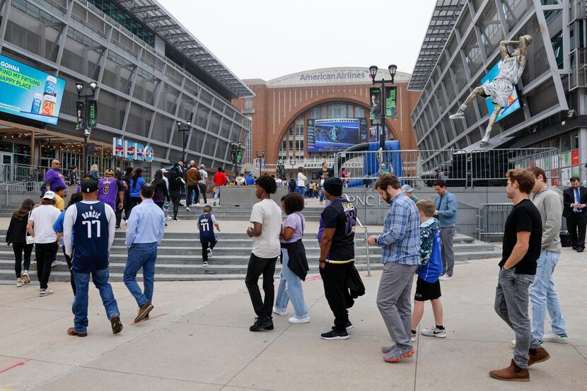 Fans wait in line to enter the arena before a game between the Dallas Mavericks and Los...