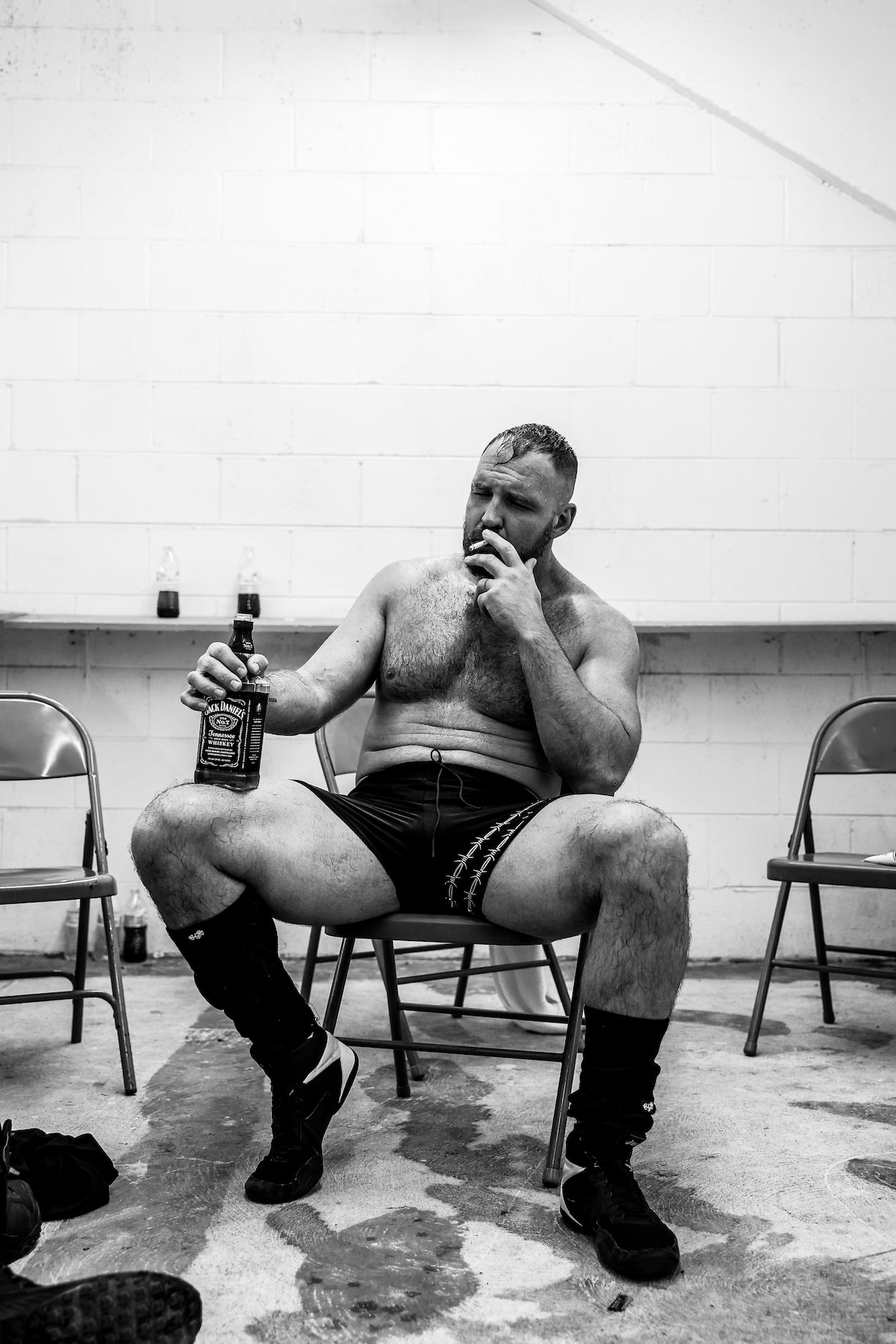 Jon Moxley smokes a cigarette while holding a bottle of Jack Daniels following his match at...