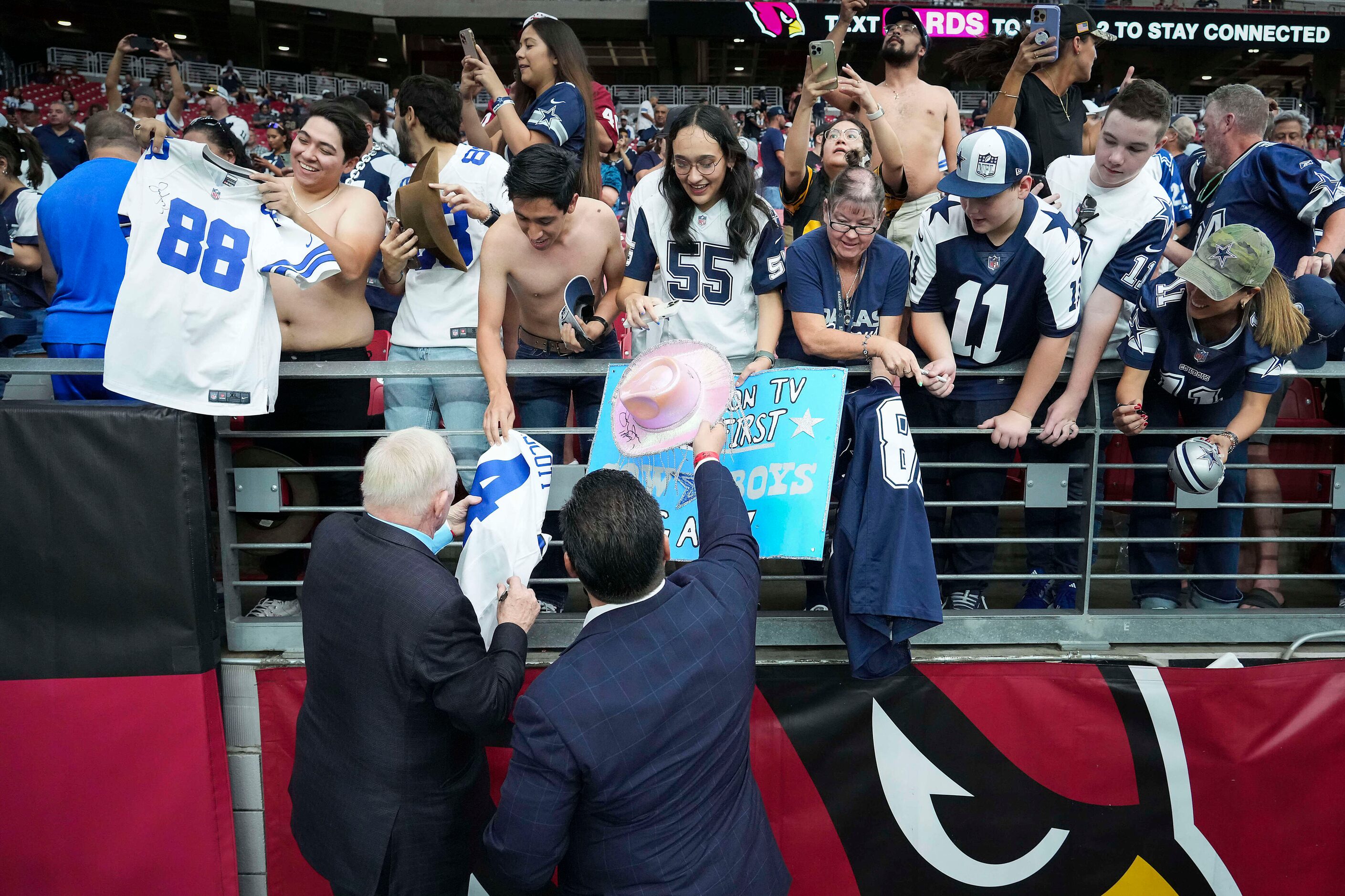 Dallas Cowboys owner and general manager Jerry Jones signs autographs before an NFL football...