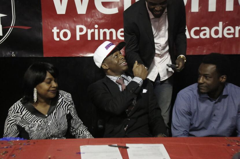 Prime Prep boys basketball player Emmanuel Mudiay (center) shakes hands with his brother...