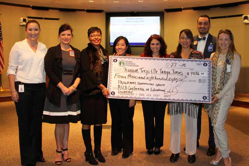  Crystal Scanio, left, presents a grant to Irving ISD staff. 
