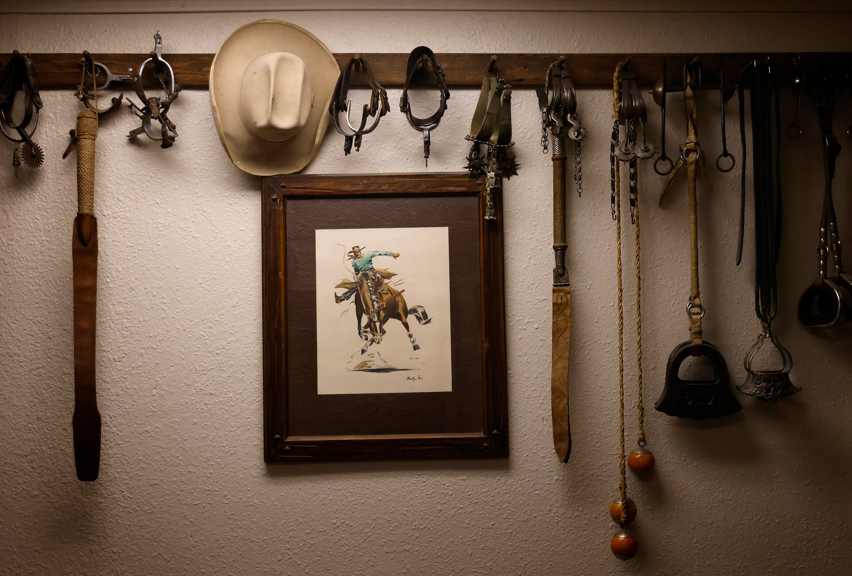 Old sets of spurs and ranching equipment hang on the wall in Daniel M. Manzanares’s office...