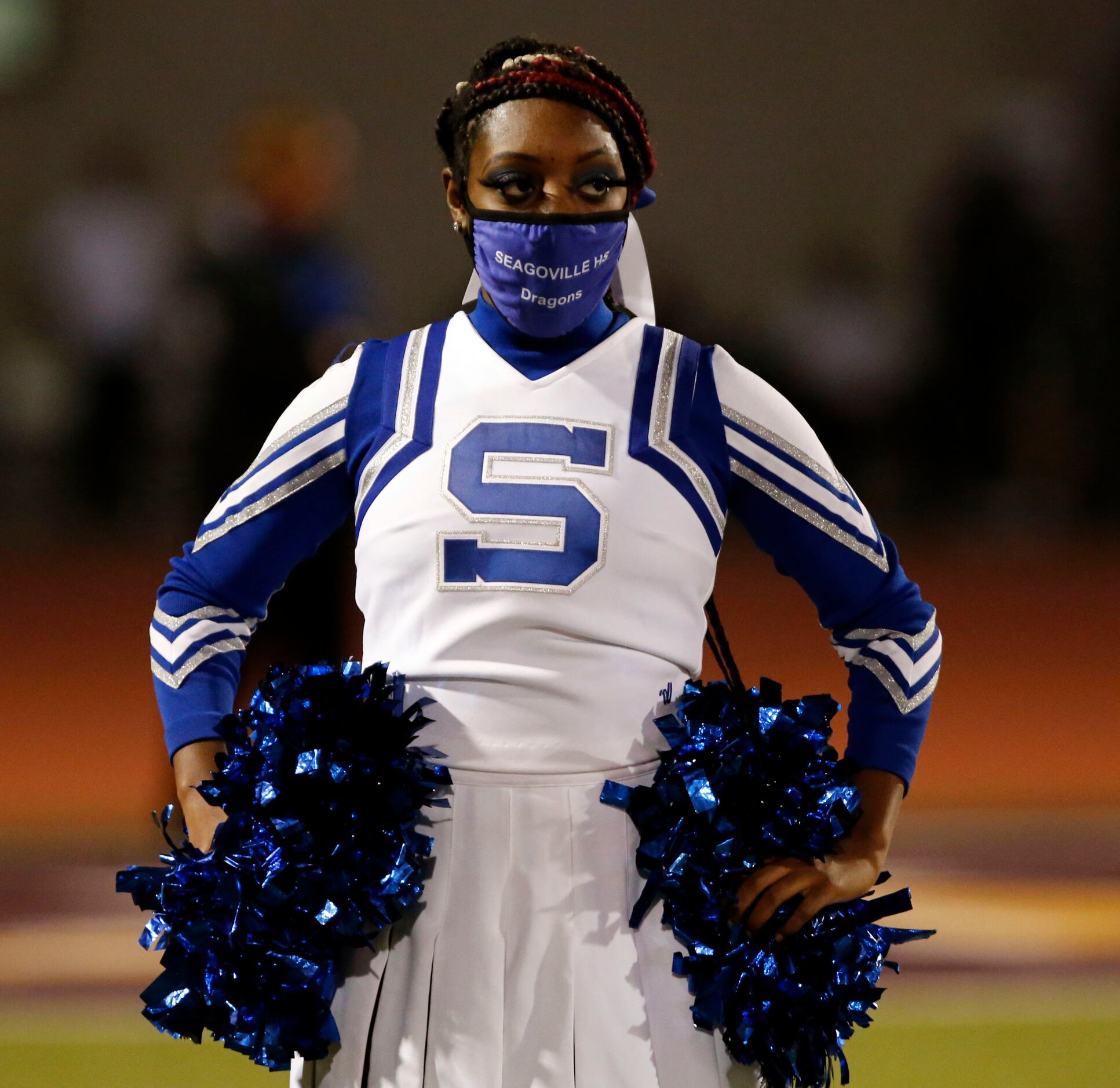 A Seagoville cheerleader stands at attention before the start of the first half of high...