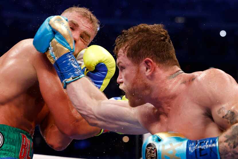 El boxeador mexicano Saúl Canelo Álvarez (der) lanza un golpe a Billy Joe Saunders durante...