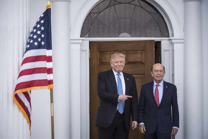 President-elect Donald Trump walks out with investor Wilbur Ross after a meeting at the...